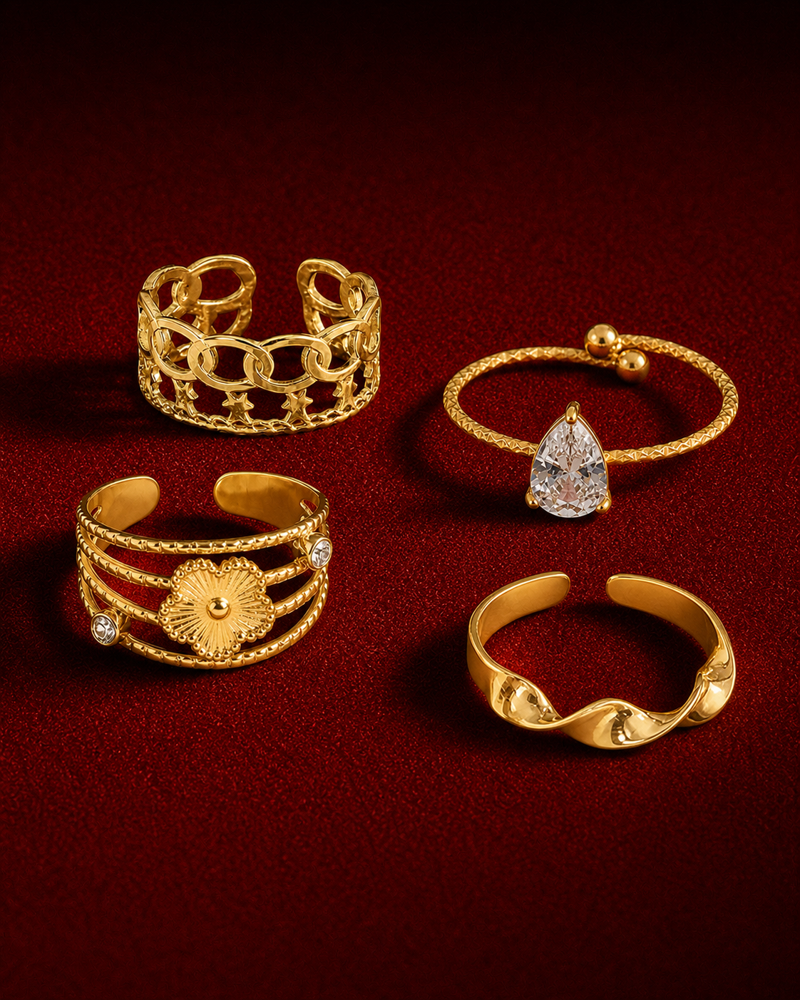 Collection de bagues dorées Amani sur fond rouge grenat