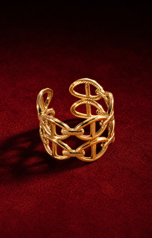 Bague dorée ajustable entrelacée sur fond rouge signature Amani by Layal