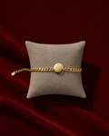 Bracelet gourmette personnalisable avec initiale sur fond rouge signature Amani by Layal