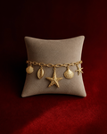 Bracelet océan coquillages et étoile de mer sur fond rouge signature Amani by Layal