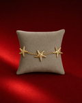 Bracelet doré aux trois étoiles de mer sur fond rouge signature Amani by Layal