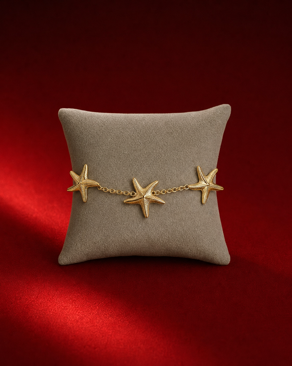 Bracelet doré aux trois étoiles de mer sur fond rouge signature Amani by Layal