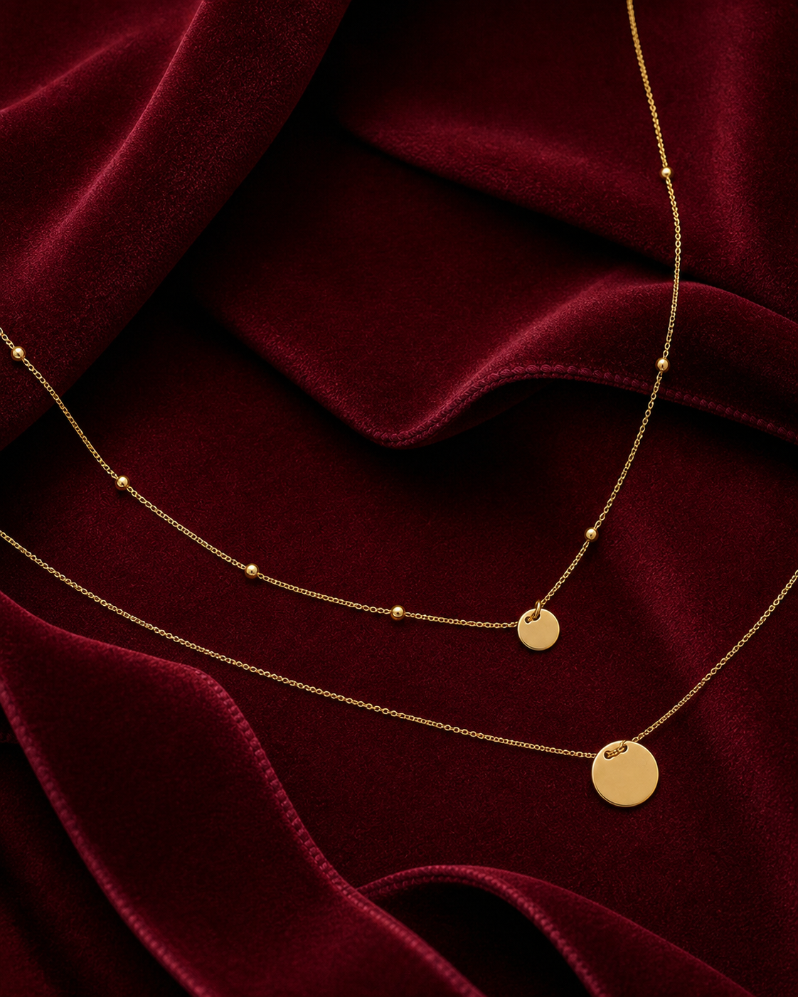 Collier doré à double chaîne et médailles sur fond rouge signature Amani by Layal