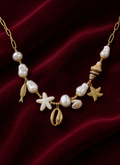Collier océan avec perles et breloques marines sur fond rouge signature Amani by Layal